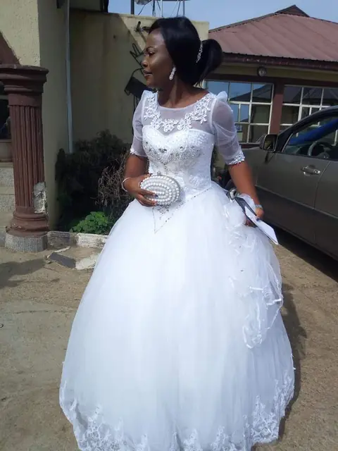Bride in a lace-sleeved ball gown on her wedding day